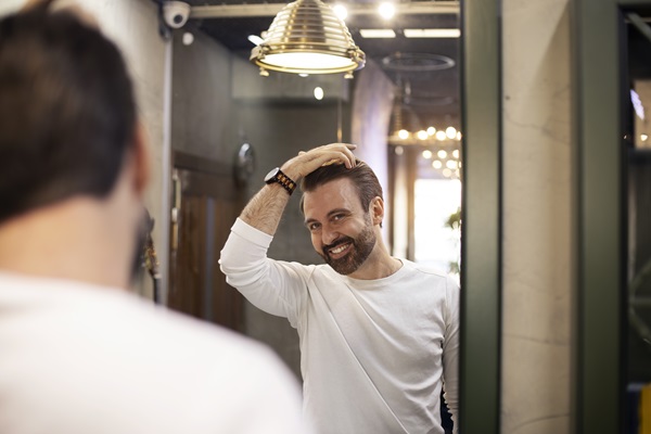 Masculino observando que su cabello está saludable y arreglado en los días previos al evento nupcial