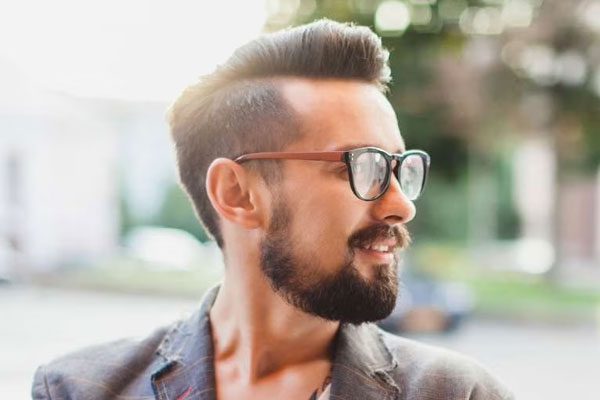 Hombres con entradas - Joven con gafas luce jovial perfil con un copete actualizado