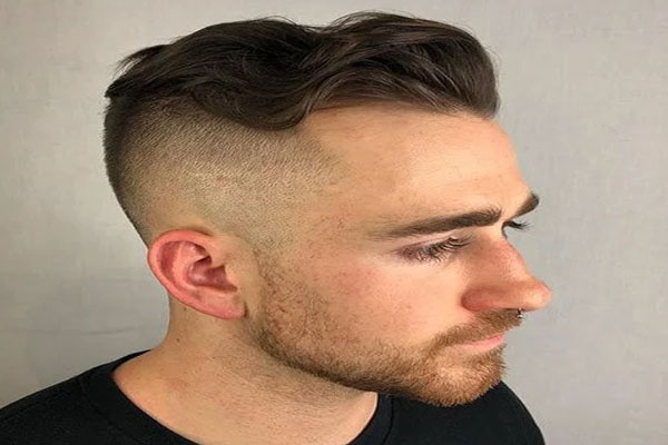 Hombres con entradas - Joven con largas pestañas disimula la pérdida de cabello de perfil con un voluminoso copete