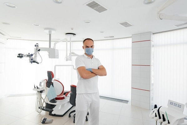 caries y calvicie - Dentista con tapabocas se siente orgulloso de dar a conocer sus nuevas instalaciones de trabajo