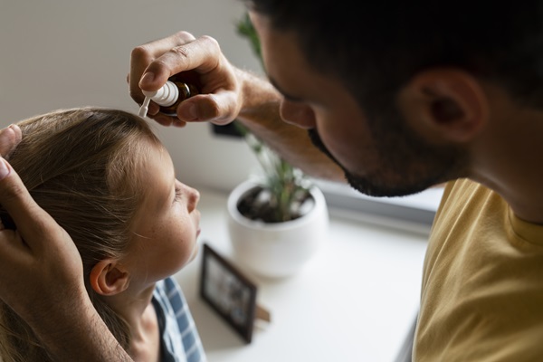 Hemangioma capilar - Padre aplicando un tratamiento en la cabeza de su hija, para quitar el hemangioma capilar que presenta