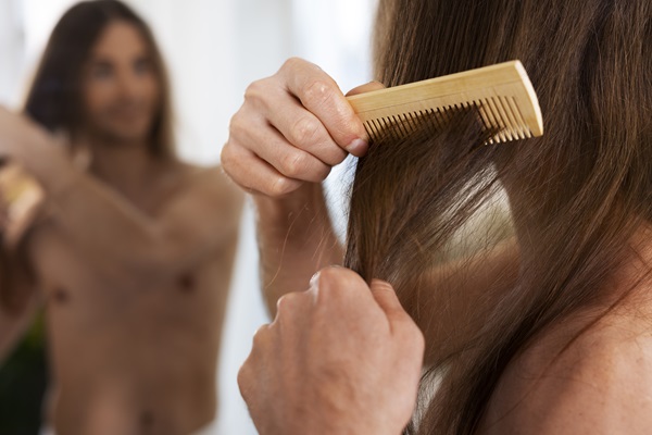 Hombre peinando su cabello liso luego del tratamiento con quina y romero