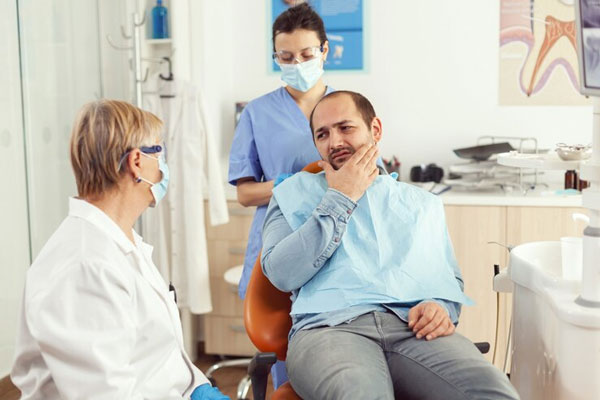 Caries y calvicie - Hombre con problemas de alopecia acude al dentista tras experimentar un punzante dolor en la boca 