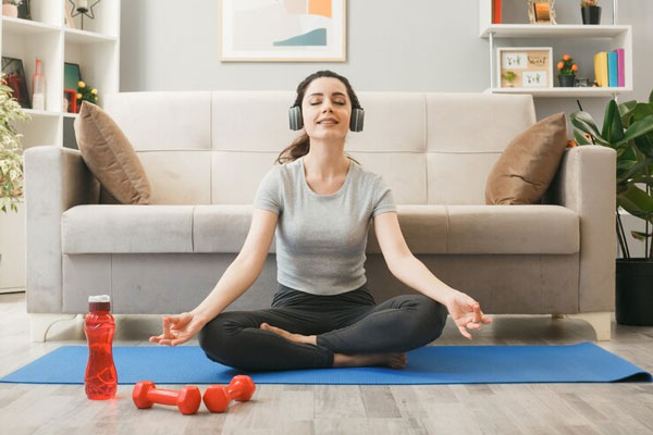 Joven hace ejercicio y practica yoga en la sala de su casa