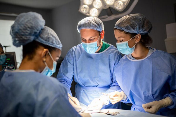Equipo médico trabaja en una intervención quirúrgica mínimamente invasiva de manera conjunta 