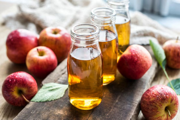 Vinagre de manzana - Frascos de vinagre de manzana sobre superficie de madera 