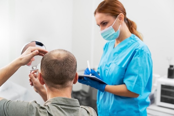Dermatólogo en el injerto capilar - Dermatóloga atendiendo a un paciente con alopecia, para evaluar su cuero cabelludo y recomendar la técnica más adecuada para recuperar el cabello