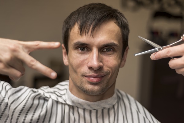Pelo tras injerto capilar - Hombre cortándose el cabello con tijera, lo cual le ayuda a tener mayor cuidado para no dañar el pelo recién implantado