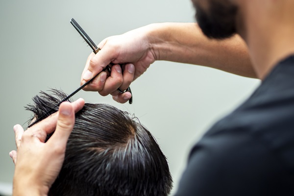 Pelo tras injerto capilar - Barbero cortando el cabello de un hombre con tijera, para favorecer la recuperación y no causar daños a los folículos pilosos injertados