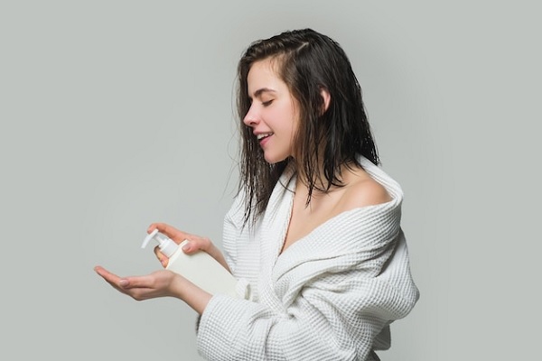 Mujer aplicando un acondicionador en el pelo, el cual ayuda a hidratar las hebras capilares