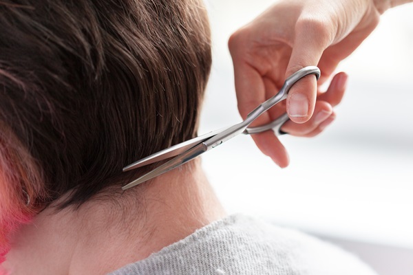 Pelo tras injerto capilar - Hombre cortando el cabello de la zona donante con tijera, para no causar daños a la cicatrización del cuero cabelludo