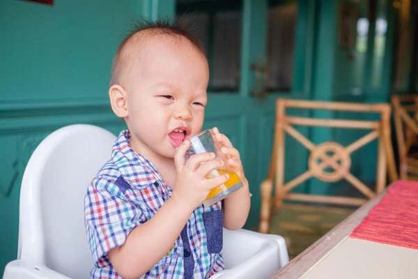 Alopecia en niños - Niño con baja densidad capilar bebiendo un jugo para consumir las vitaminas necesarias
