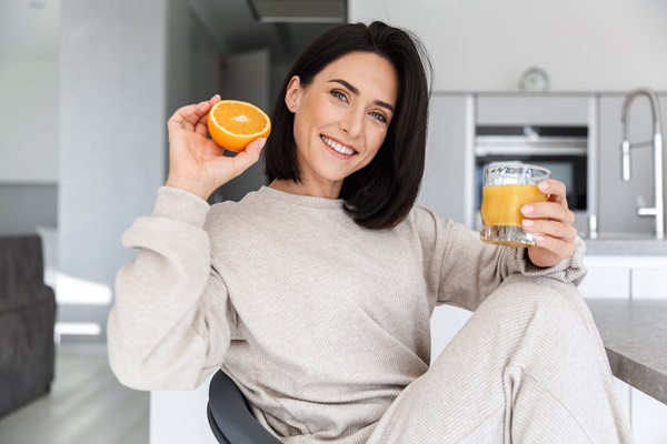 Cabello sano desde adentro - Mujer tomando un jugo de naranja, el cual es una buena fuente de vitamina A