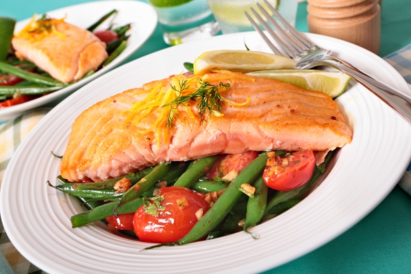 Imagen de un plato de salmón junto a varios vegetales, los cuales aportan nutrientes esenciales para una alimentación balanceada