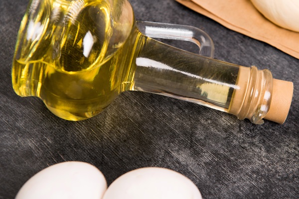 Reparar el cabello dañado - Imagen de un recipiente con aceite de oliva junto a unos huevos, lo cual sirve para crear una mascarilla capilar que hidrata y devuelve el brillo al cabello