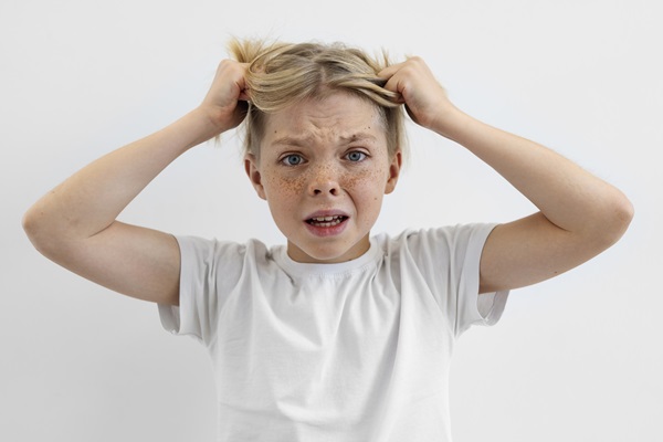 Alopecia en niños - Niña jalando su cabello debido al exceso de estrés, lo cual causa daño a las hebras capilares