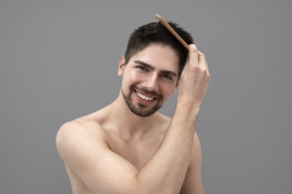 Hombre peinando su pelo de manera suave, para evitar causar daños a las hebras capilares