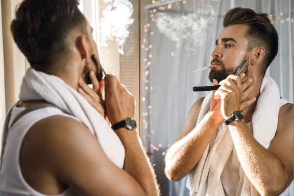 Hombre afeitando su rostro para moldear el vello facial, consiguiendo un estilo acorde a sus rasgos físicos