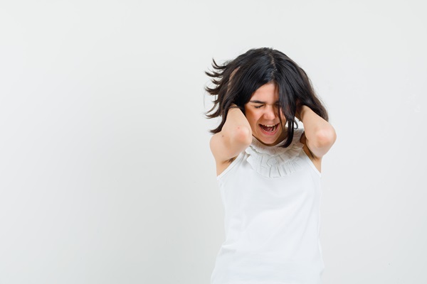 Alopecia androgénica en mujeres - Mujer estresada sujetando su cabeza, debido a situaciones emocionales difíciles
