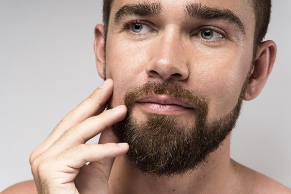 Hombre posando con un vello facial perfectamente cuidado, lo cual lo hace lucir muy atractivo