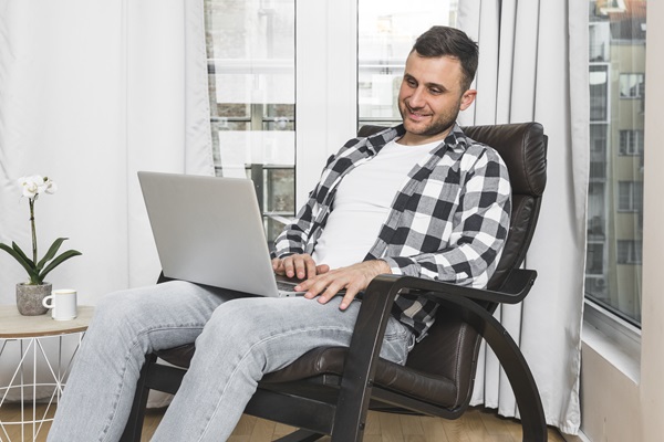 Recomendaciones tras trasplante capilar - Hombre trabajando desde casa sin realizar mucha actividad física, para favorecer la recuperación del cuero cabelludo luego del trasplante capilar
