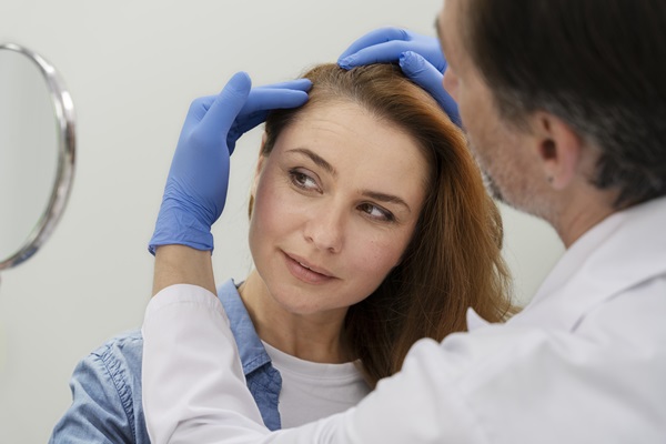 Dermatólogo en el injerto capilar - Dermatólogo examinando el cuero cabelludo de una mujer, para diagnosticar la razón por la cual pierde cabello en exceso
