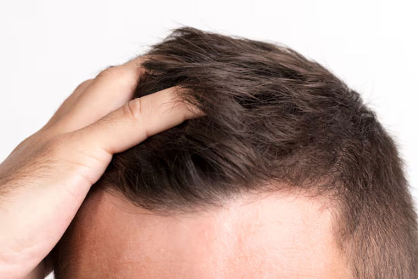 Primer plano de la mano de un hombre tocando su cabello