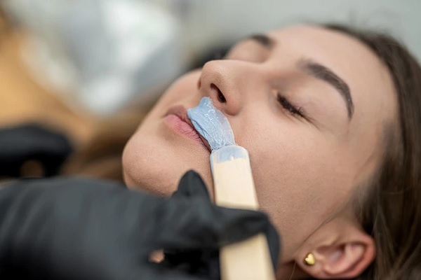 Hirsutismo hormonal - Joven visita al esteticista para eliminar el vello indeseado del labio superior