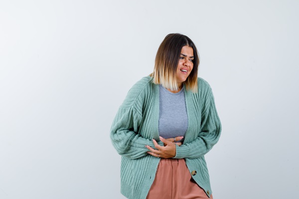 Espironolactona - Mujer sujetando su abdomen con las manos, debido a un fuerte dolor de estómago