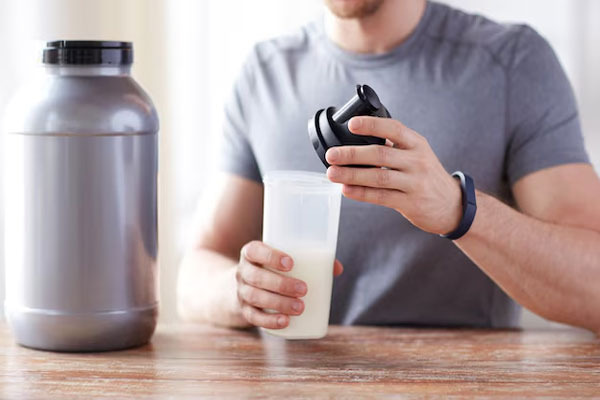 Batidos de proteína y calvicie - Hombre prepara un batido de proteína para ganar masa muscular