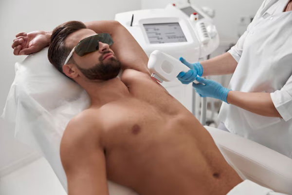Hombre con gafas protectoras y pecho desnudo recurre a un tratamiento de depilación láser para eliminar el vello corporal