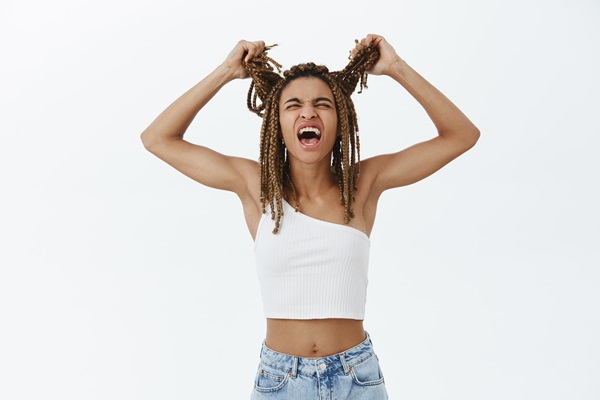 Tricorrexis nudosa - Mujer joven jalando su cabello con cara de desesperación