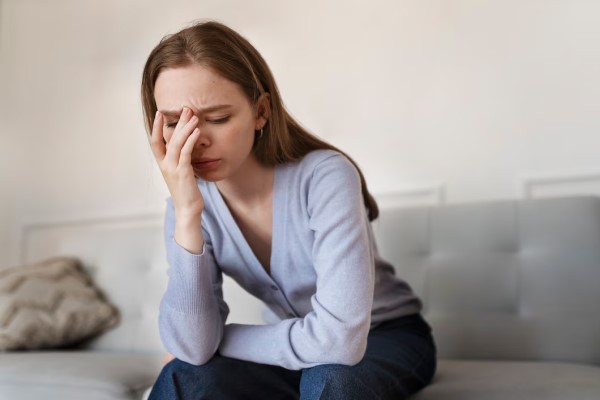  mujer sentada en el sofá con problemas de estrés