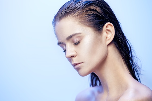 Hair slugging - Mujer joven con el cabello húmedo y los ojos cerrados