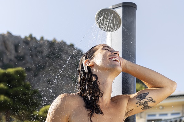 Cloro de las piscinas - Hombre joven lava su cabello en una ducha al aire libre