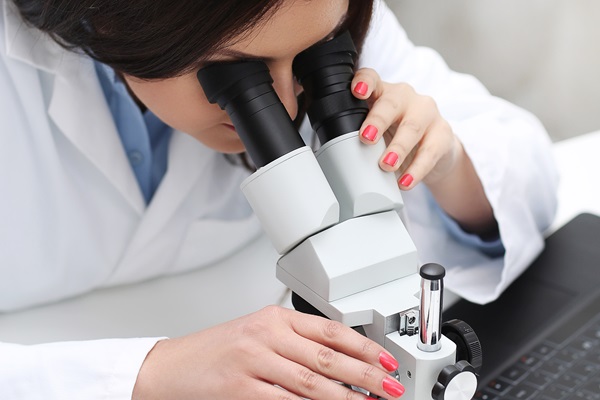Mujer científica utiliza el microscopio en un laboratorio