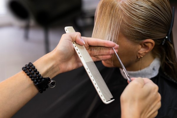 mujer en la peluquería cortándose las puntas del cabello