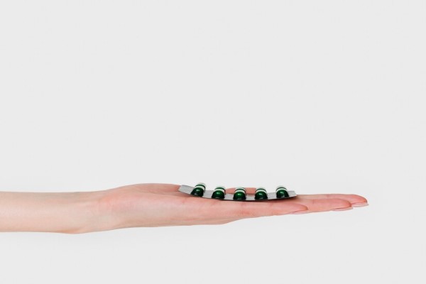  injerto capilar - mujer con un blíster de pastillas en la mano