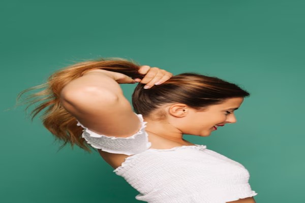 mujer realizándose una coleta larga en la melena