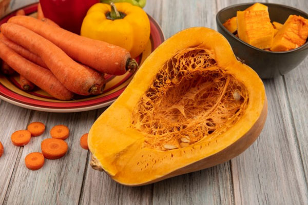 Poliosis - Calabaza y zanahorias sobre una mesa como parte de un ejemplo de alimentos ricos en caroteno