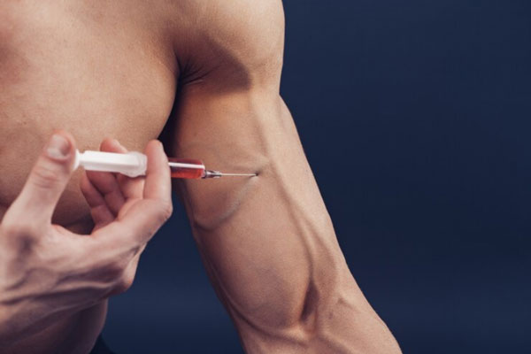 Esteroides anabólicos - Hombre musculoso recurre a una solución inyectable para estimular la hipertrofia muscular
