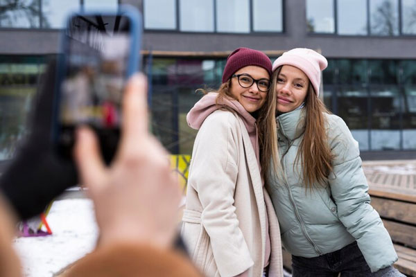 Jóvenes posan para una foto y usan chaquetas y gorros para proteger su cabello del frío 