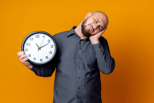 Insomnio afecta el pelo - Hombre calvo con reloj en mano enfrenta dificultades para conciliar el sueño