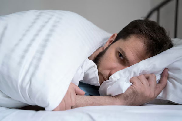 Insomnio afecta el pelo - Hombre con alopecia y con altos niveles de estrés y ansiedad intenta dormir de lado