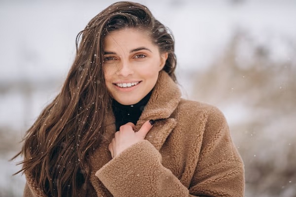 Cabello en invierno - Joven de cabello liso y abundante usa un abrigo para cubrirse de la nieve 