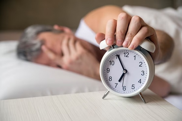 Insomnio afecta el pelo - Hombre adulto con alopecia apaga la alarma tras pasar una mala noche