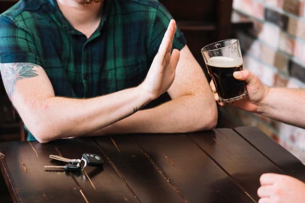 hombre diciendo no a una cerveza para reducir los ronquidos por la noche y evitar la calvicie