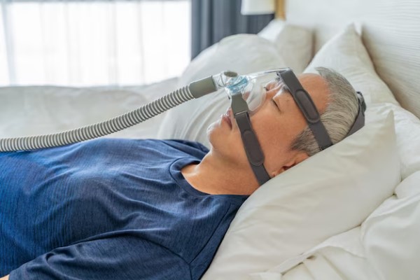 hombre usando una maquina CPAP para evitar los ronquidos por la noche y la calvicie