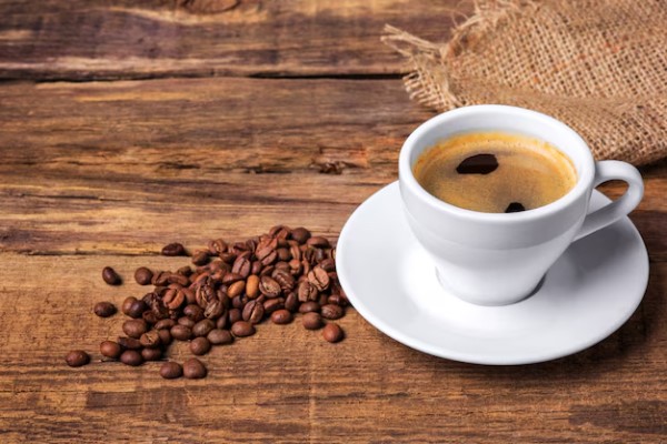 roncar provoca alopecia - taza de café sobre una mesa de madera con granos de café