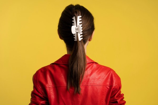 Accesorios para el cabello 2 - mujer de espaldas con una pinza para el cabello sujetando su pelo